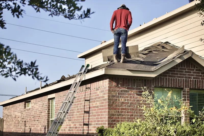Professional roofer working on a residential roof in Tower District